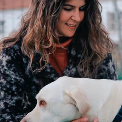 Una adiestradora acariciando a un perro